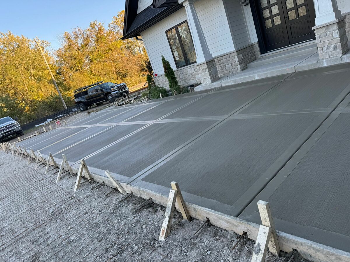 Crew pouring and leveling a large concrete slab